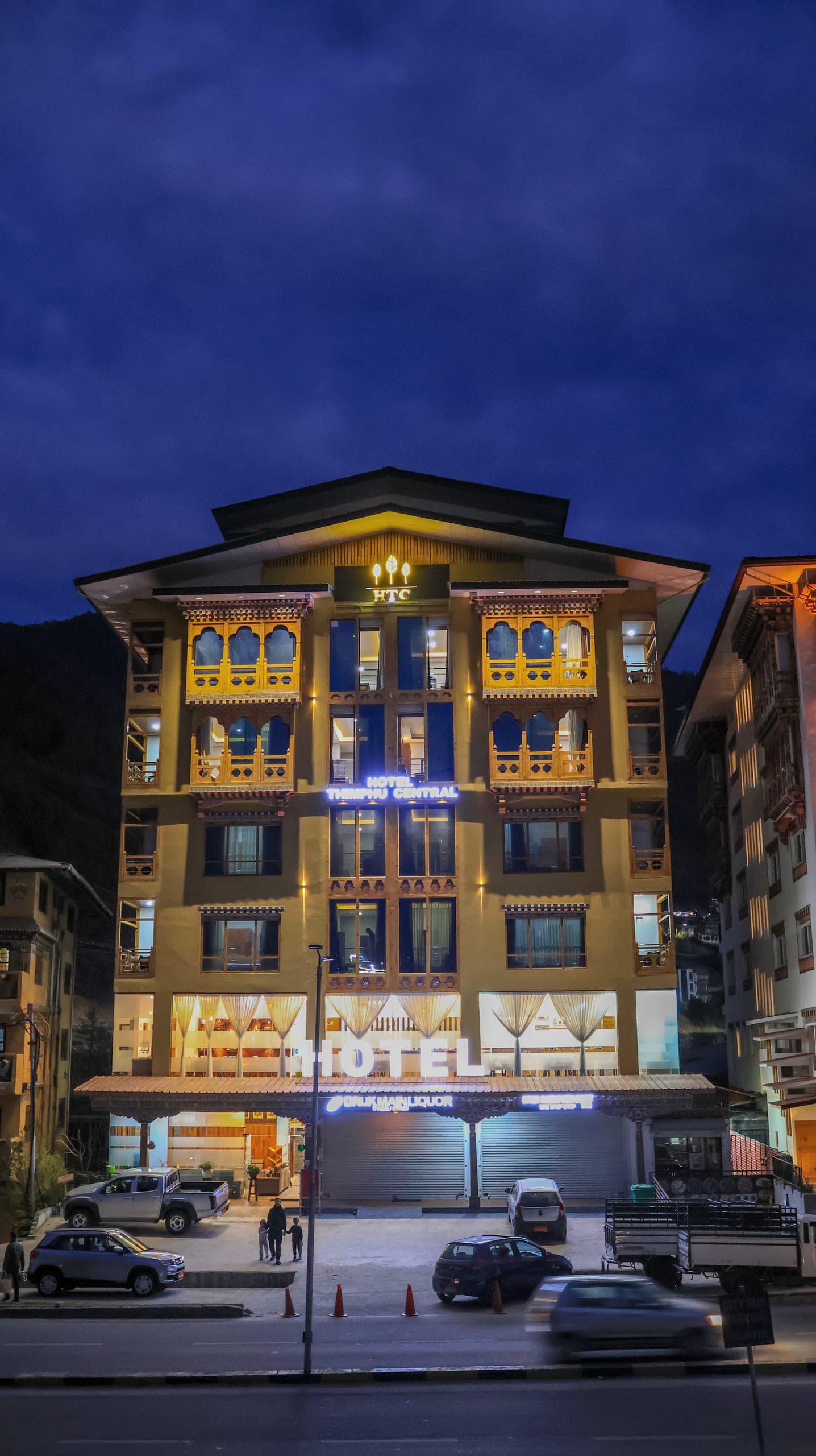 Front of Hotel Thimphu Central at night with its illuminated sign