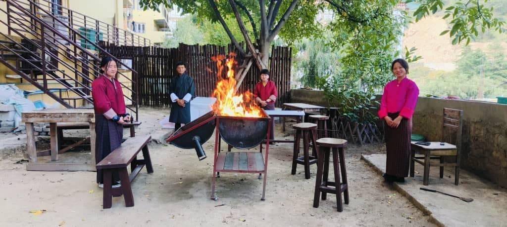 Bonfire in the garden backyard with hotel staff in traditional dress