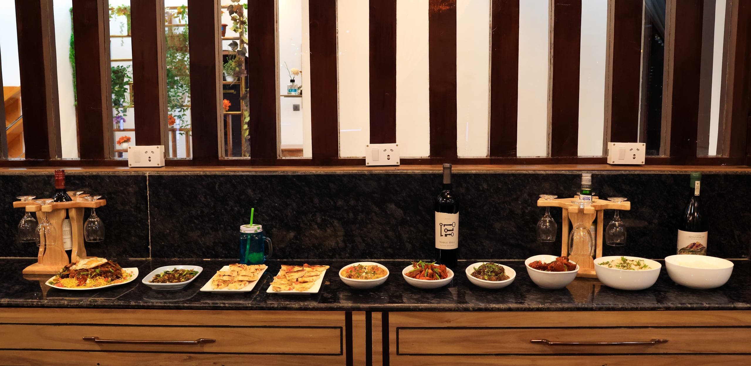 Buffet counter with a row of dishes on a dark stone top