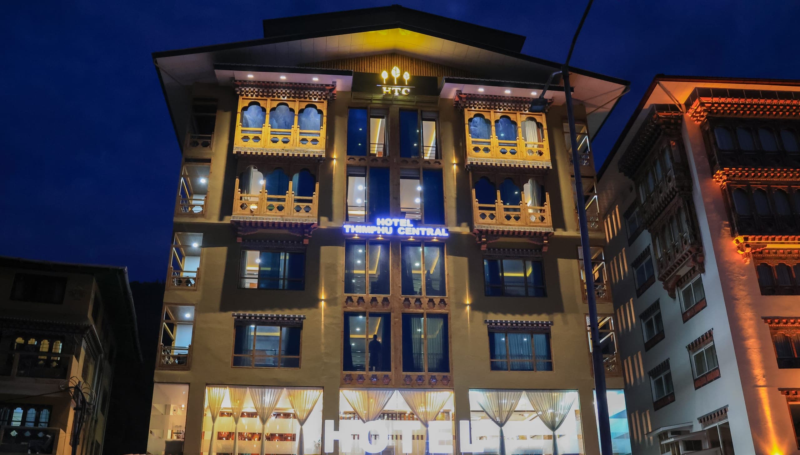 Hotel Thimphu Central's Bhutanese-style building lit up at dusk
