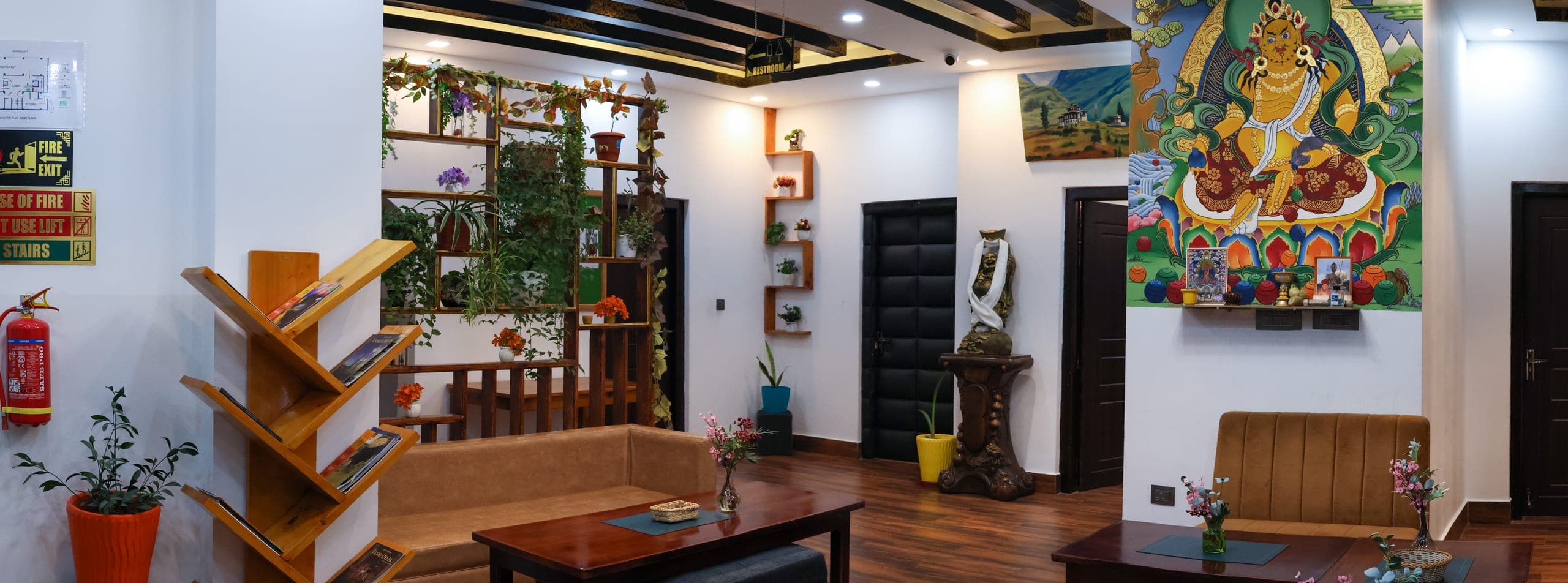 Hotel lobby with a large thangka painting, seating and plants