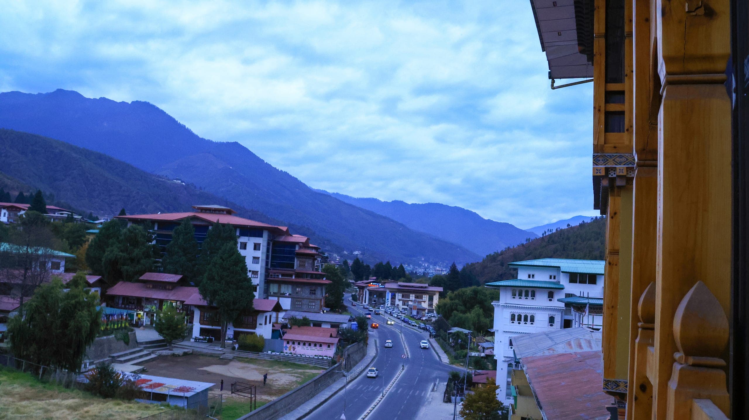 Road, town and forested mountains seen from the front of the hotel